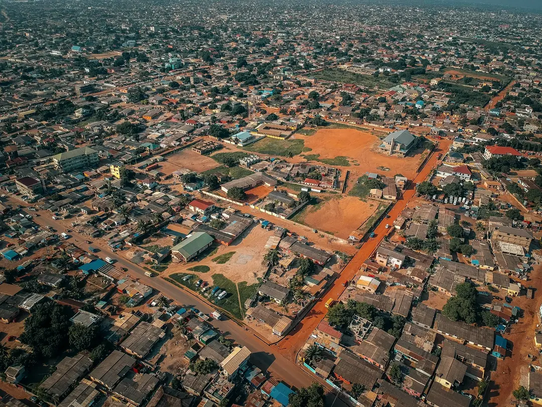 Accra from above: red laterite roads between rooftops and trees